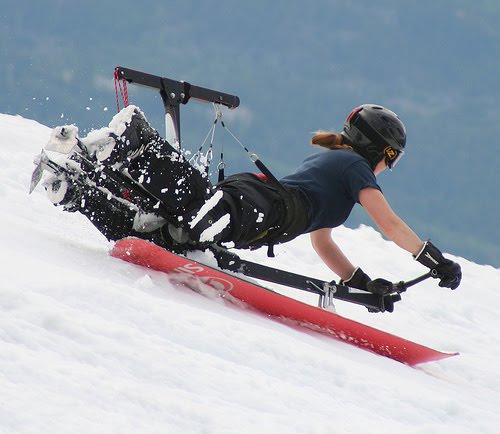 Rider on a prototype device attached to a snowboard speeding down a snowy slope.